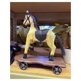 wood horse on cart with metal wheels