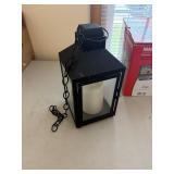 hanging black lantern with chain, candle is