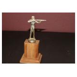 A Metal Statue on Wooden Base