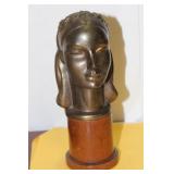 A Metal Bust on a Wood Stand