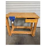 Rolling wooden work bench with vice and one door