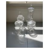 Set of four vintage clear glass apothecary jars.