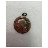 A sterling silver religious medallion with the
