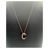 A sterling silver necklace with the letter C.