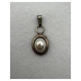 A sterling silver pendant with pearl like stone