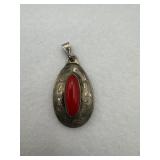 A sterling silver pendant with a oval blood red