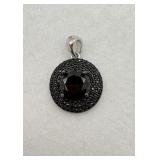 A sterling silver pendant with a black stone with