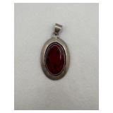 A sterling silver oval pendant with black and red