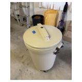 Tan plastic trashcan with wheels and lid