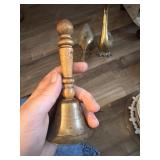 This vintage brass bell features a turned wooden