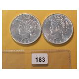 Two AU Peace Silver Dollars