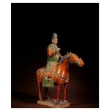 THE MING TRI-COLOR GLAZED POTTERY FIGURE OF AN...
