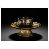 A BLACK LACQUER HIGH-FOOTED CUP HOLDER FROM THE...