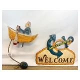 METAL WELCOME SIGN AND MOTION MAN IN BOAT ROWING