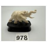 CARVED BONE ELEPHANT DISPLAYED ON A WOOD BASE, 2