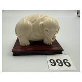 CARVED BONE ELEPHANT ON A WOOD PEDESTAL BASE.