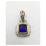 SILVER AND GOLD TONE PENDANT WITH DARK BLUE STONE