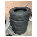 FOUR BLACK RUBBER AUTOMOTIVE TIRES STACKED