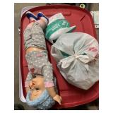 RED PLASTIC STORAGE BIN CONTAINING PLASTIC DOLL