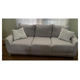 GRAY UPHOLSTERED SOFA W/ THROW PILLOWS.