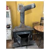 BLACK CAST IRON WOOD BURNING STOVE W/ STOVEPIPE.