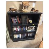 BLACK BOOKCASE WITH ASSORTMENT OF BOOKS AND DVDS
