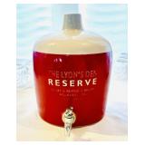 Glass beverage dispenser titled 'The Lyons' Den'