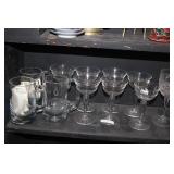 A SHELF OF GLASS MUGS AND STEWARE