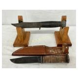 Two Ka-Bar Knives with Leather Sheath and Wood Dis Two Ka-Bar Knives with Leather Sheath and Wood Dis