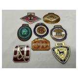 Eight Metal Fobs Featuring Logos and Emblems