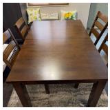 Dining table with 4 chairs and bench with pillows. Table has 2 leafs