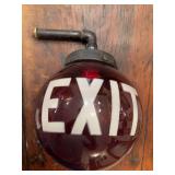 Glass EXIT sign with black pipe-style connector. Industrial-style display piece with bold lettering and vintage architectural salvage appeal, suitable for shop, office, bar, garage, theater, or advert