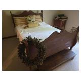 Full-size bed with bed stool. Bed measures approximately 49 in. tall x 57 in. wide x 83 in. long. Located on second floor; buyer should bring help and tools for removal.