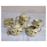 Five-piece grouping of Hall China Autumn Leaf pieces including a covered teapot, covered sugar bowl, creamer and two additional coordinating serving/accessory pieces, all with ivory glaze, Autumn Leaf