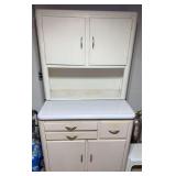 Vintage painted Hoosier-style kitchen cabinet with upper double-door storage, open work area, lower cupboards and multiple drawers. White painted finish with chrome-tone hardware.