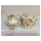 Five-piece Hall Autumn Leaf group including two lidded teapots, pitcher, covered sugar bowl and serving tray, all with gold trim. Tray and photographed teapot are marked “Made Especially for The Aut
