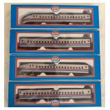 Four boxed Model Power Amtrak model railroad pieces in silver with red, white and blue striping. Includes engines and passenger cars as shown.