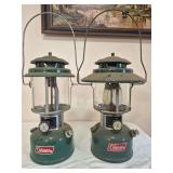 Coleman Models 220K & 228H Lanterns – Marked 2/82 & 9/73. Green double-mantle pressure lanterns with clear globes and wire bail handles, including the wide-ventilator 228H; shows age-related wear an