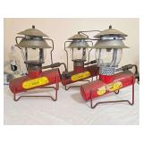 Three Bernzomatic Model TX700 propane gas lanterns with red horizontal fuel cylinders, metal support stands, clear globes and silver-tone ventilators. Labels remain present, with paint wear, oxidation