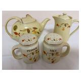 China Specialties Autumn Leaf grouping including lidded teapot, lidded pitcher and handled salt and pepper shakers in cream glaze with multicolor Autumn Leaf decoration and gold-tone trim. Shows gener