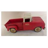 Vintage Tonka pressed-steel pickup truck in red with white cab roof and Tonka Mound, Minn. oval decal. Shows paint wear and oxidation consistent with age.