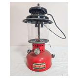 Vintage KampLite Model RL-32B pressure lantern with red painted fount, black ventilator, clear Coleman-marked Pyrex globe and black wire bail handle. Shows paint wear, oxidation and general age-relate