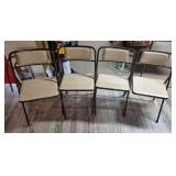Set of Four Vintage Metal & Vinyl Chairs. Matching chairs feature dark tubular-metal frames with light beige vinyl upholstered seats and backrests.