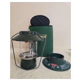 Coleman Model 5154B Propane Lantern with Case. Green portable propane lantern with clear globe, wire frame, Coleman carrying case and removable reflector/shade accessory as shown.