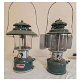 Coleman Models 228F & 220E Lanterns – 220E Marked 2/56. Pair of vintage green double-mantle pressure lanterns with green porcelain ventilators, clear globes and wire bail handles; shows age-related 