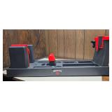 Hoppe’s 9 molded gun cleaning and maintenance stand with adjustable red-and-black supports and built-in accessory compartments.