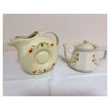 Two Hall Autumn Leaf pieces including a 1991 Autumn Leaf Club Donut Water Pitcher and a 2004 N.A.L.C.C. Bellevue Teapot, both in ivory with Autumn Leaf decoration and gold trim. The Bellevue teapot is