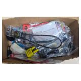 Box full of assorted gun locks including cable locks, padlock-style locks and other firearm locking devices, many individually bagged as shown.