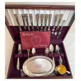 Silver plate grouping housed in a fitted wood storage chest, including assorted flatware, serving pieces, engraved tray and cup as shown.