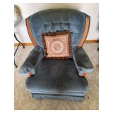 Two upholstered armchairs as cataloged; the first chair swivels. Includes a blue upholstered example with tufted back, padded arms and wood-tone trim as shown.